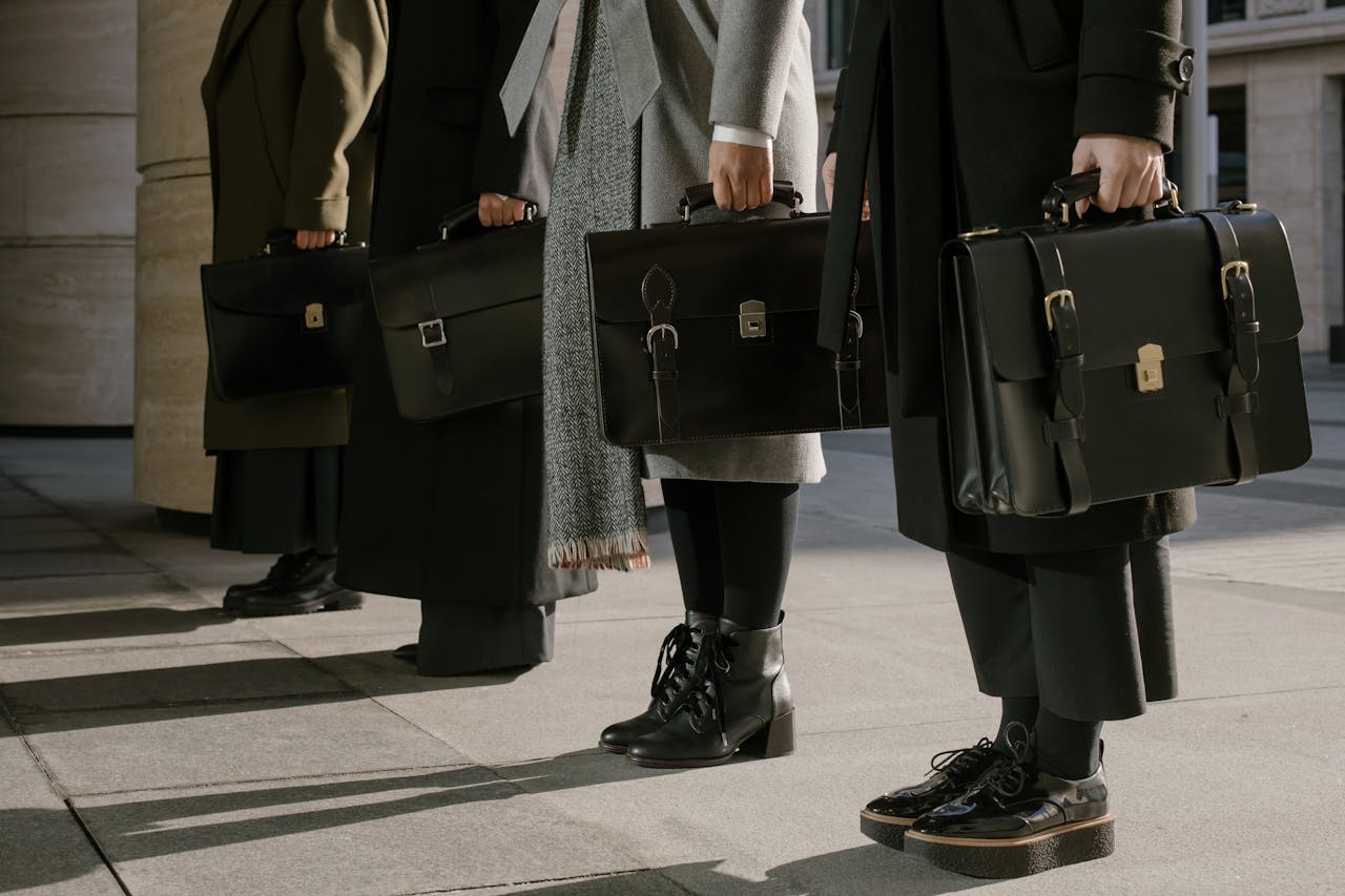 Services Three professionals stand with leather briefcases, illustrating business style.